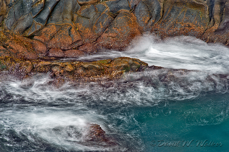 Waves crashing against volcanic rock at shoreline