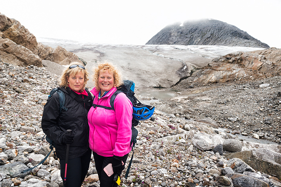 Sisters pose for picture at moraine base before beginning a trekking adventure on Lemon Glacier, Juneau Icefield, Juneau, Alaska, USA