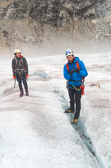 Guide explains geology of glaier on a trekking adventure on Lemon Glacier, Juneau Icefield, Juneau, Alaska, USA